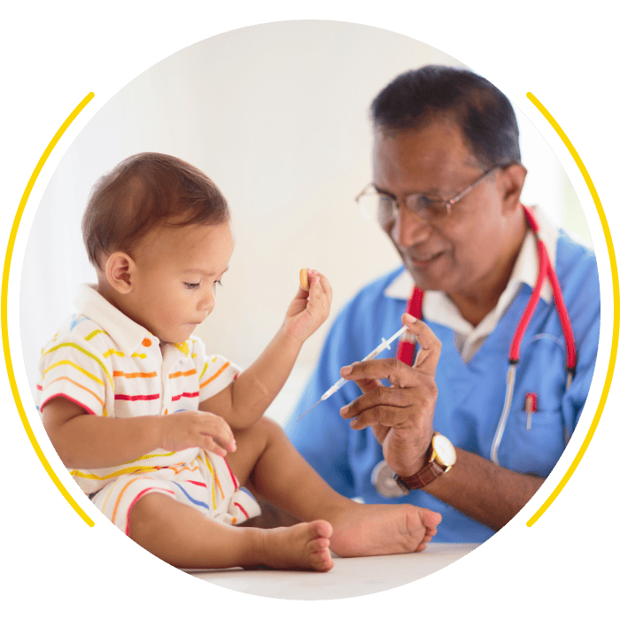 Pediatrician prepares to give a vaccination to a young child, showing friendly medical care.