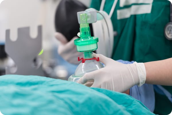 An anesthesiologist giving anesthesia to a patient during a surgery.
