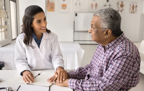 A healthcare professional counselling an elderly patient.
