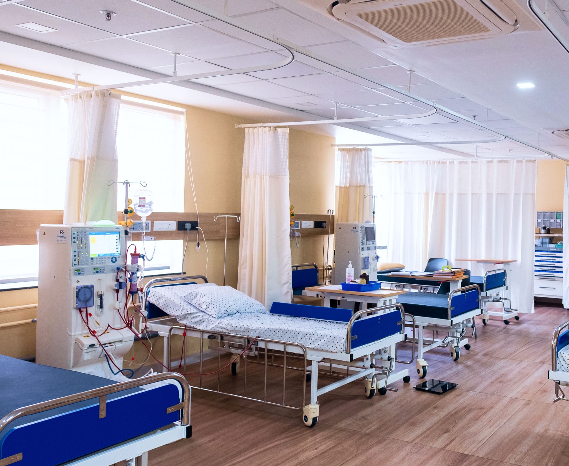 Several empty beds with dialysis machines at Porunai Hospital in Tirunelveli.