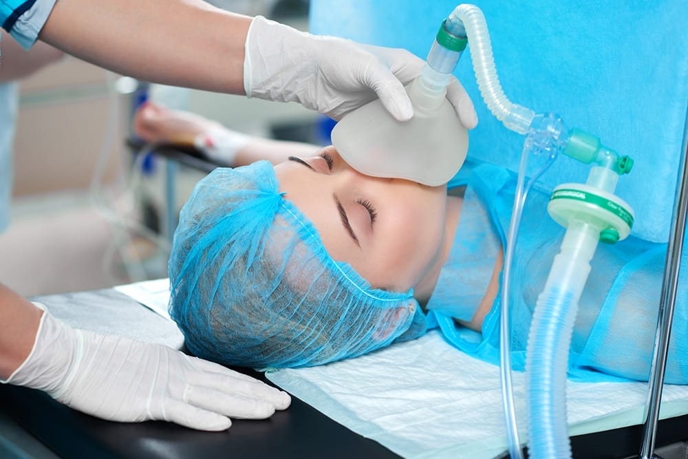 A patient receives anaesthesia through a face mask before a medical procedure.